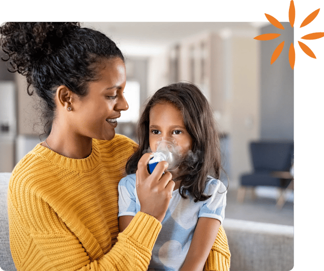 Parent helping a child use a nebulizer mask for an asthma treatment.